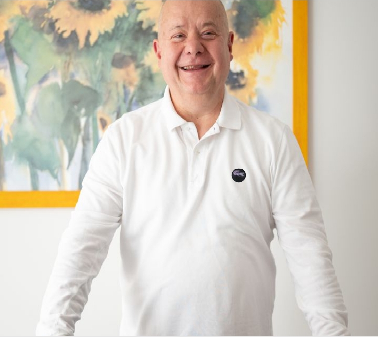 Salute nelle tue mani, il nuovo progetto del CIO Mauro Fornari, osteopata, sorridente in polo bianca, in un ambiente luminoso davanti a un grande quadro dai toni gialli e verdi.